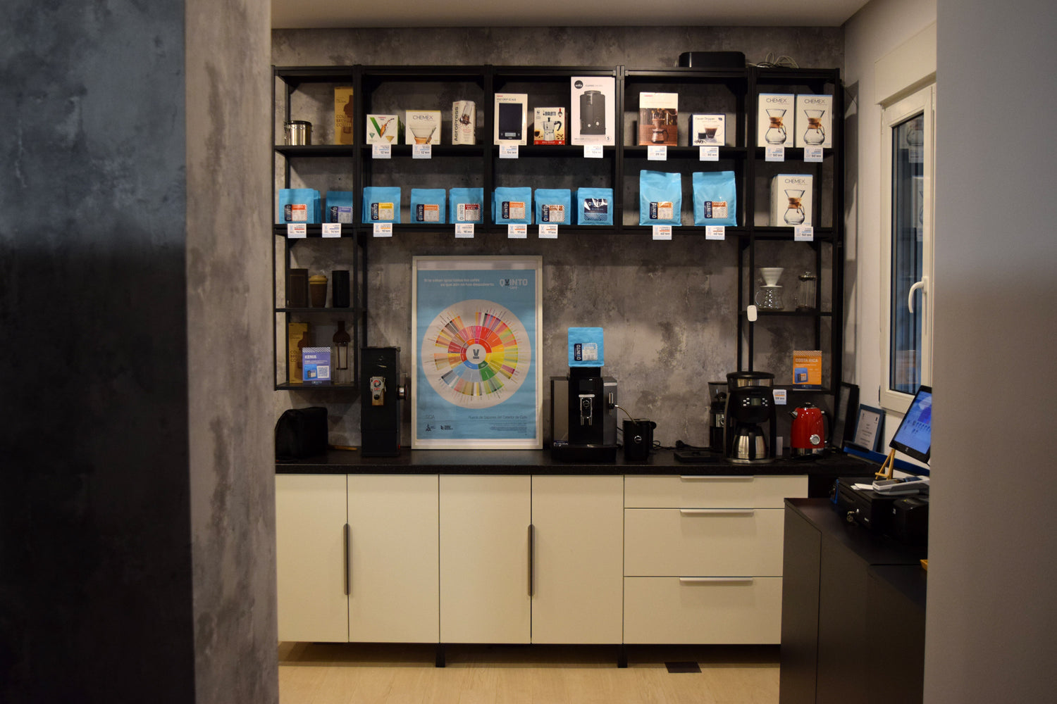 Interior de Quinto Lab: exhibición de cafés de especialidad en grano y molido junto a una cuidada selección de utensilios para preparar el mejor café. Un espacio acogedor diseñado para los amantes del buen café.