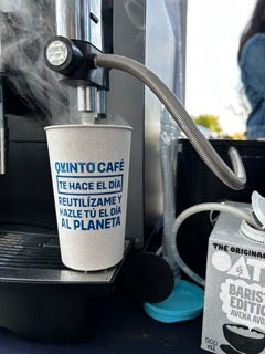 Vaso de café reutilizable de Quinto Café con el mensaje 'Reutilízame y hazle el día al planeta'. La opción sostenible para disfrutar tu café para llevar con impacto positivo.